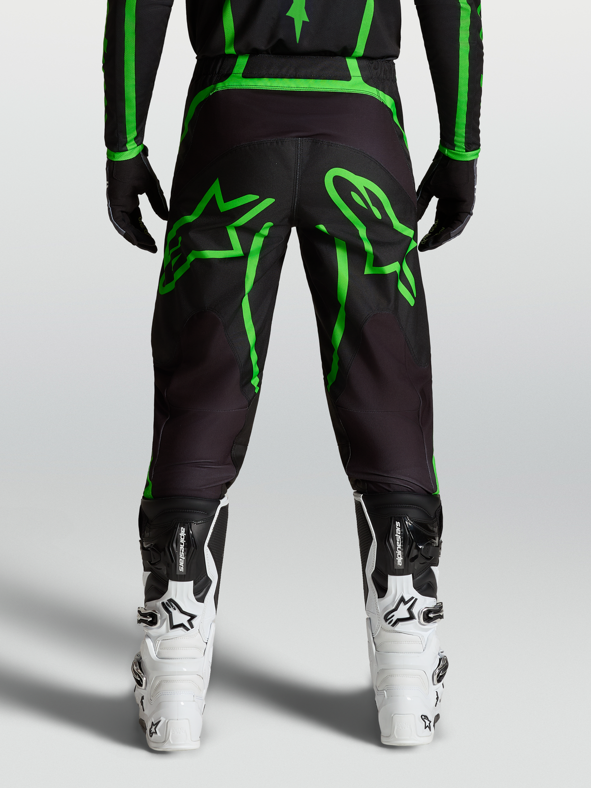 Alpinestars Fluid Apex V2 Pants, Men's Motocross Pants in Black and Fluo Green with large star graphics, rear view on-model.