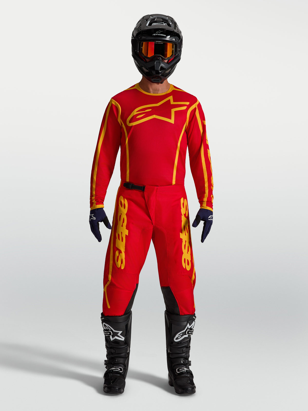 Alpinestars Fluid Apex V2 Jersey AND Fluid Apex V2 Gear Set, Men's Motocross Racing Apparel, Fire Red and Gold, moisture-wicking textile construction, shown on model with full riding kit.