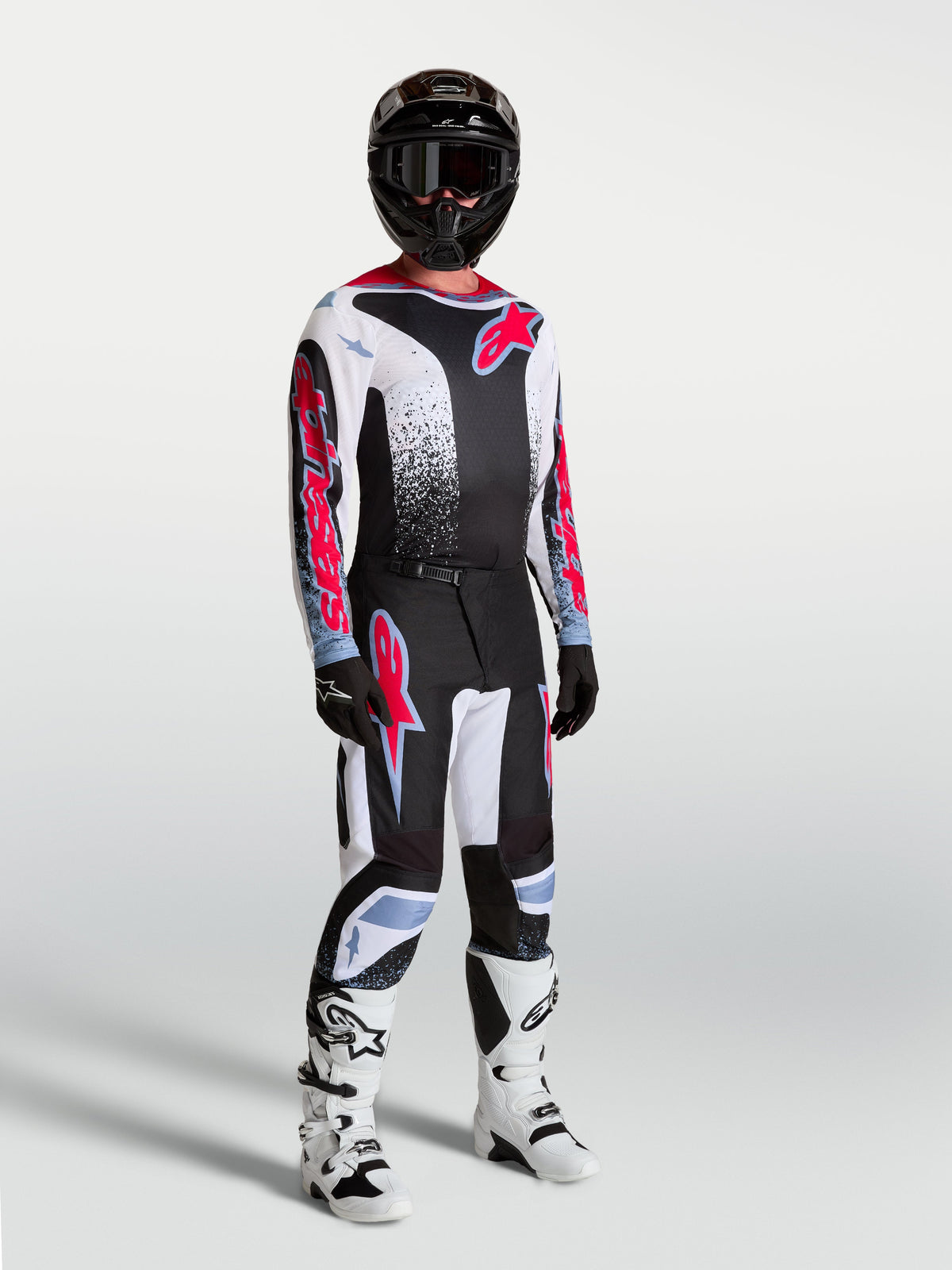 Alpinestars 2027 Fluid Drag Gear Set, conjunto de motocross para hombre en negro y blanco con gráficos rojos y botas blancas.