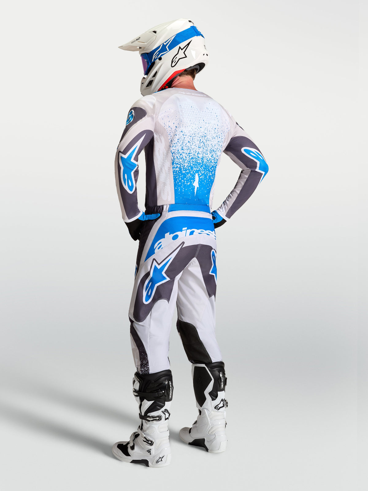 Alpinestars Fluid Drag Gear Set, conjunto de motocross para hombre con jersey y pantalones en gris y azul, vista trasera de equipamiento técnico MX de alto rendimiento