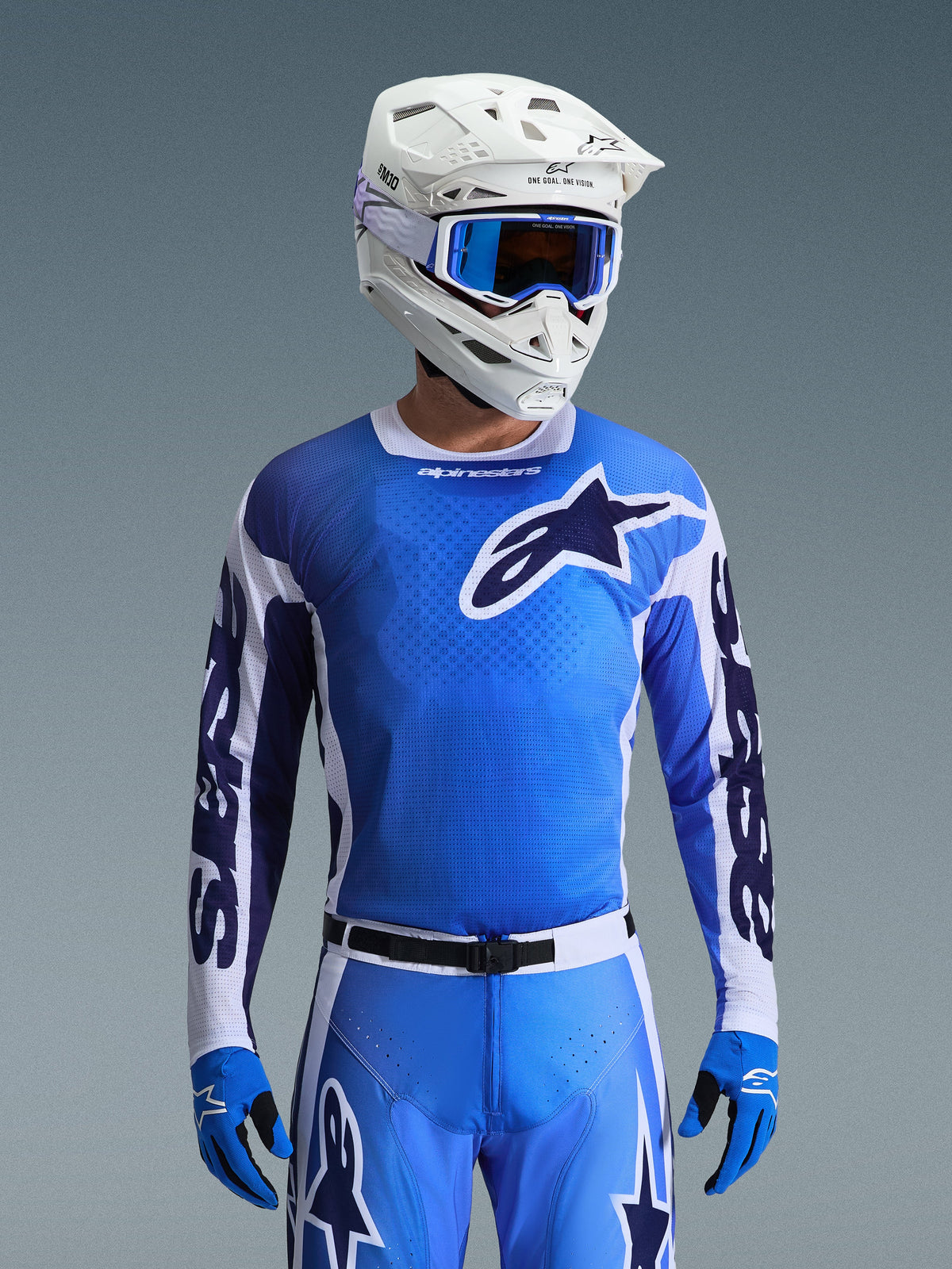 Alpinestars 2026 Racer Air Portl Jersey en azul Ucla y blanco, jersey de motocross con construcción de malla transpirable y un llamativo logotipo de estrella, usado por un piloto con pantalones a juego, casco blanco y gafas azules para un conjunto de equipamiento de carreras off-road coordinado.