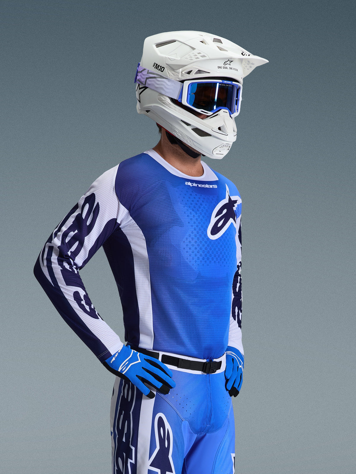 Alpinestars 2026 Racer Air Portl Jersey, jersey de motocross, azul Ucla y blanco, usado con casco blanco, gafas azules y guantes a juego, con un diseño de malla transpirable para carreras todoterreno en altas temperaturas.