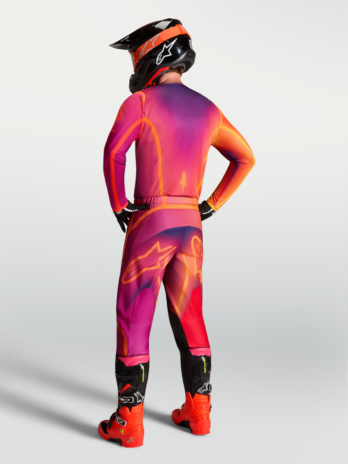 Pantalones Alpinestars Fluid Kepler de motocross para hombre, morado y naranja, vista trasera con ajuste deportivo ergonómico.