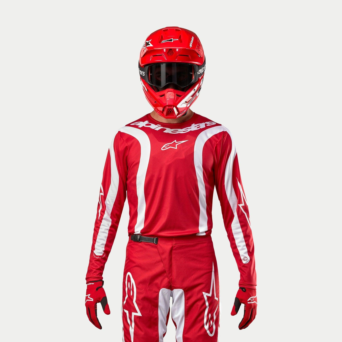 Alpinestars Fluid Lurv Jersey 2024, jersey de motocross, rojo marte y blanco, usado con pantalones, casco y guantes rojos a juego, con detalles gráficos blancos en las mangas y logotipo llamativo en el pecho, ajuste atlético para carreras todoterreno