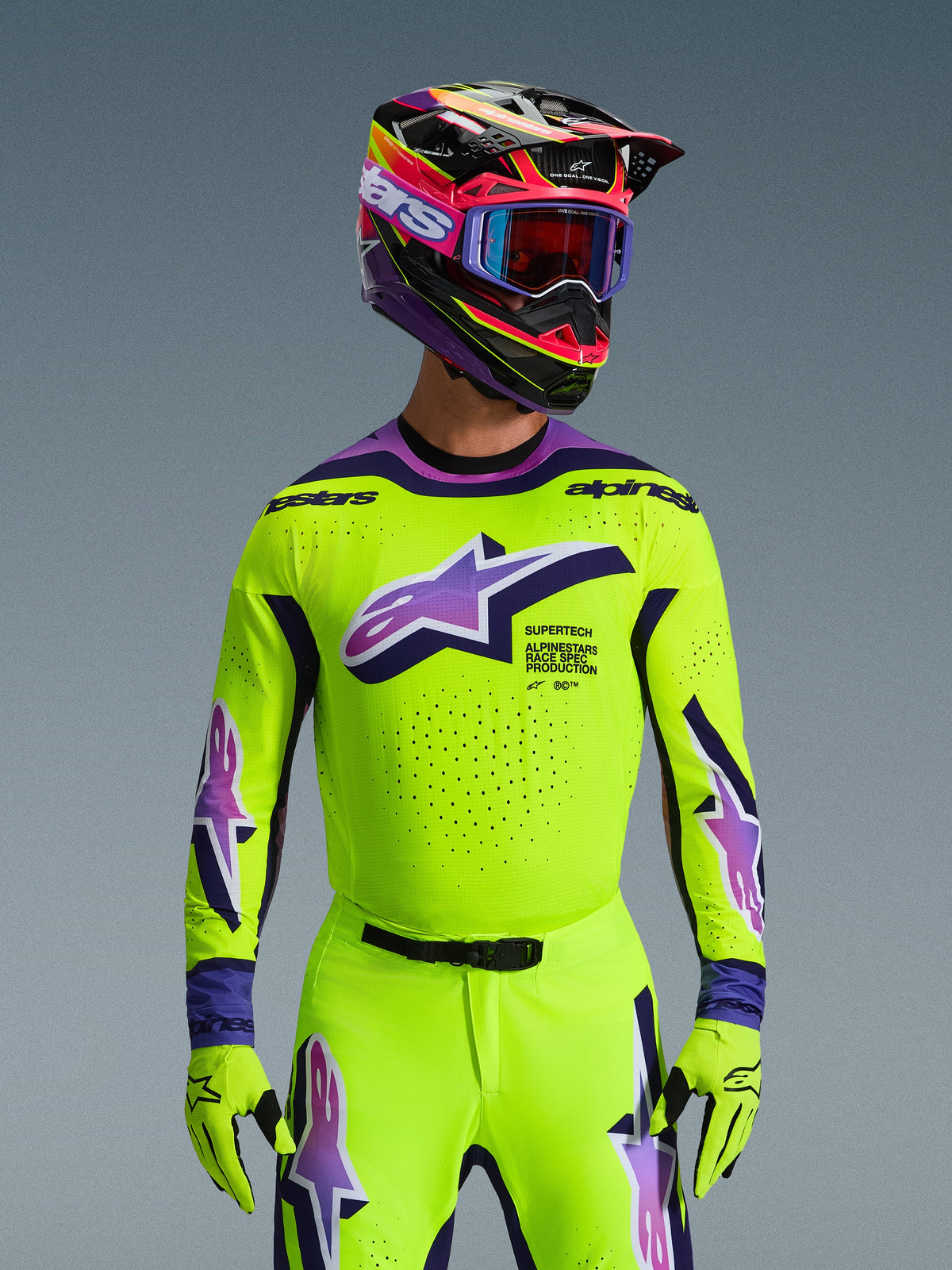 Alpinestars 2026 Supertech Vista Gear Set, piloto de motocross con jersey y pantalones amarillos de alta visibilidad con detalles en púrpura y azul, logotipo grande de Alpinestars en el pecho, casco y gafas coloridas a juego, equipación de carreras de nivel profesional