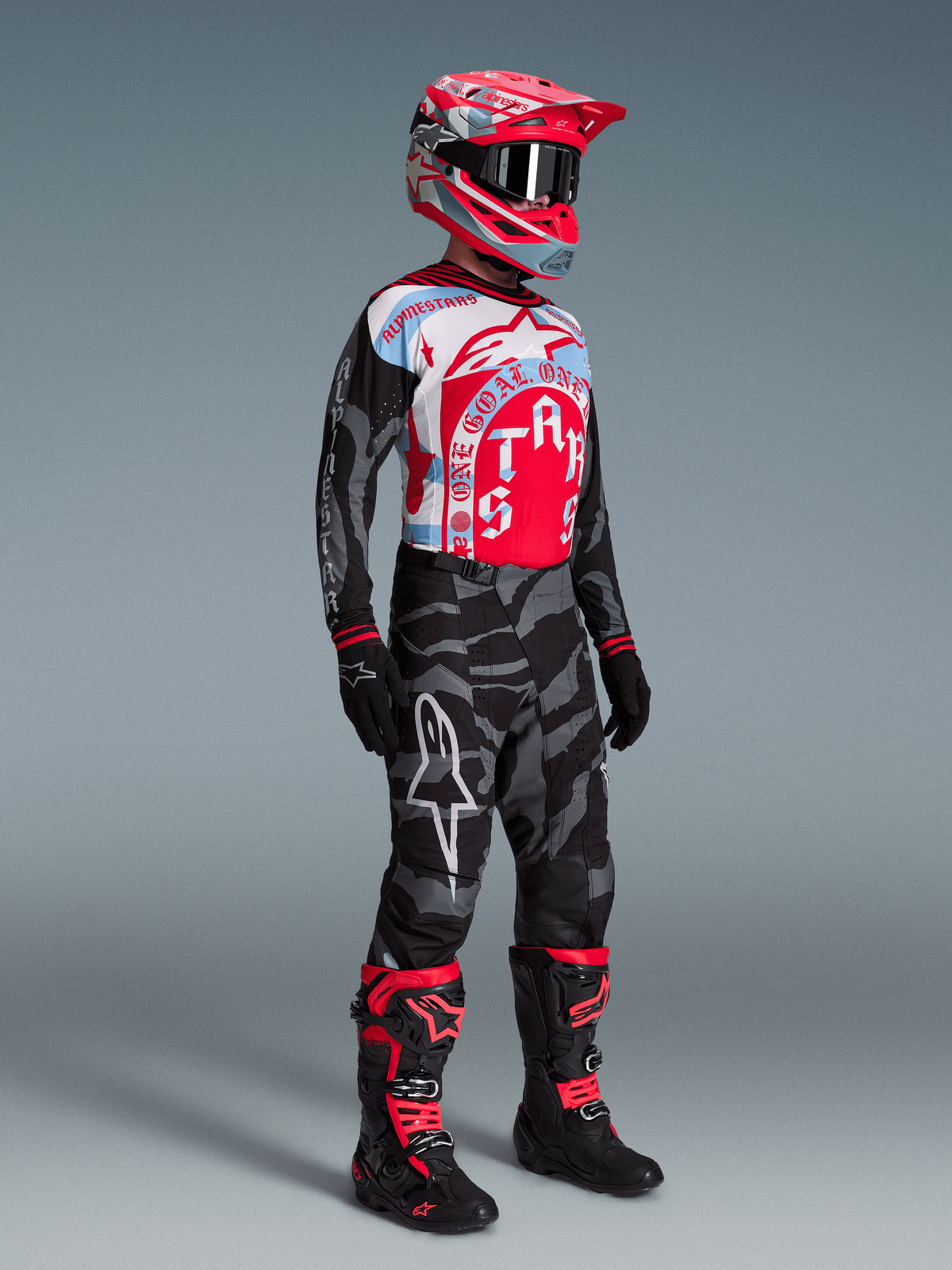 Conjunto Alpinestars Techstar Beast Coast, jersey gráfico rojo y azul, pantalones de camuflaje y botas de motocross.