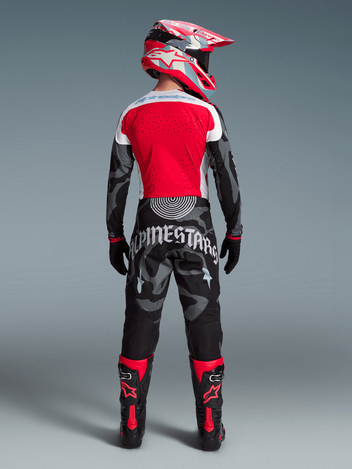 Conjunto Techstar Beast Coast Edición Limitada, piloto de espaldas con pantalones de camuflaje y jersey rojo de motocross.