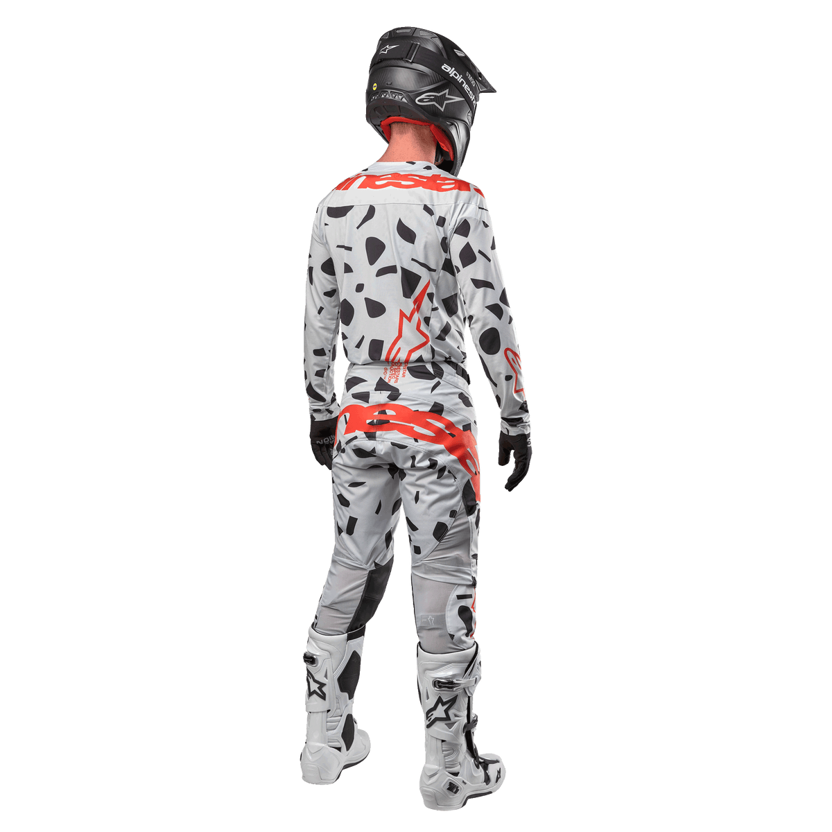 Motocross rider from behind wearing Alpinestars 2024 Techstar Rantera Jersey and matching pants, Haze Gray Camo pattern with bold red Alpinestars logos, black helmet, white and black boots, black gloves, coordinated motocross gear set.