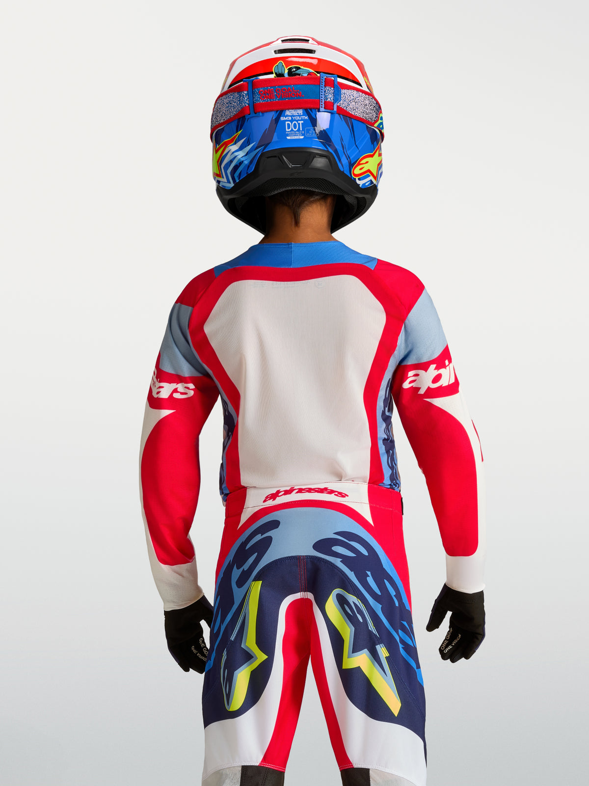 Jersey Alpinestars Supertech Dyna juvenil 2027 de motocross, rojo y azul marino, malla elástica, vista trasera en piloto.