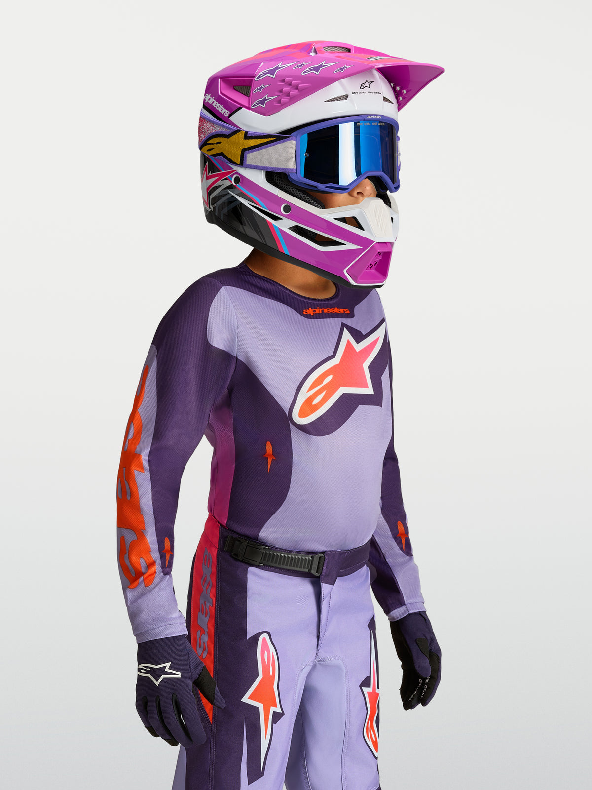Jersey Alpinestars Fluid Hunt Juvenil 2027, equipo de motocross juvenil, morado y violeta, construcción de tejido transpirable, usado por un piloto joven con casco a juego