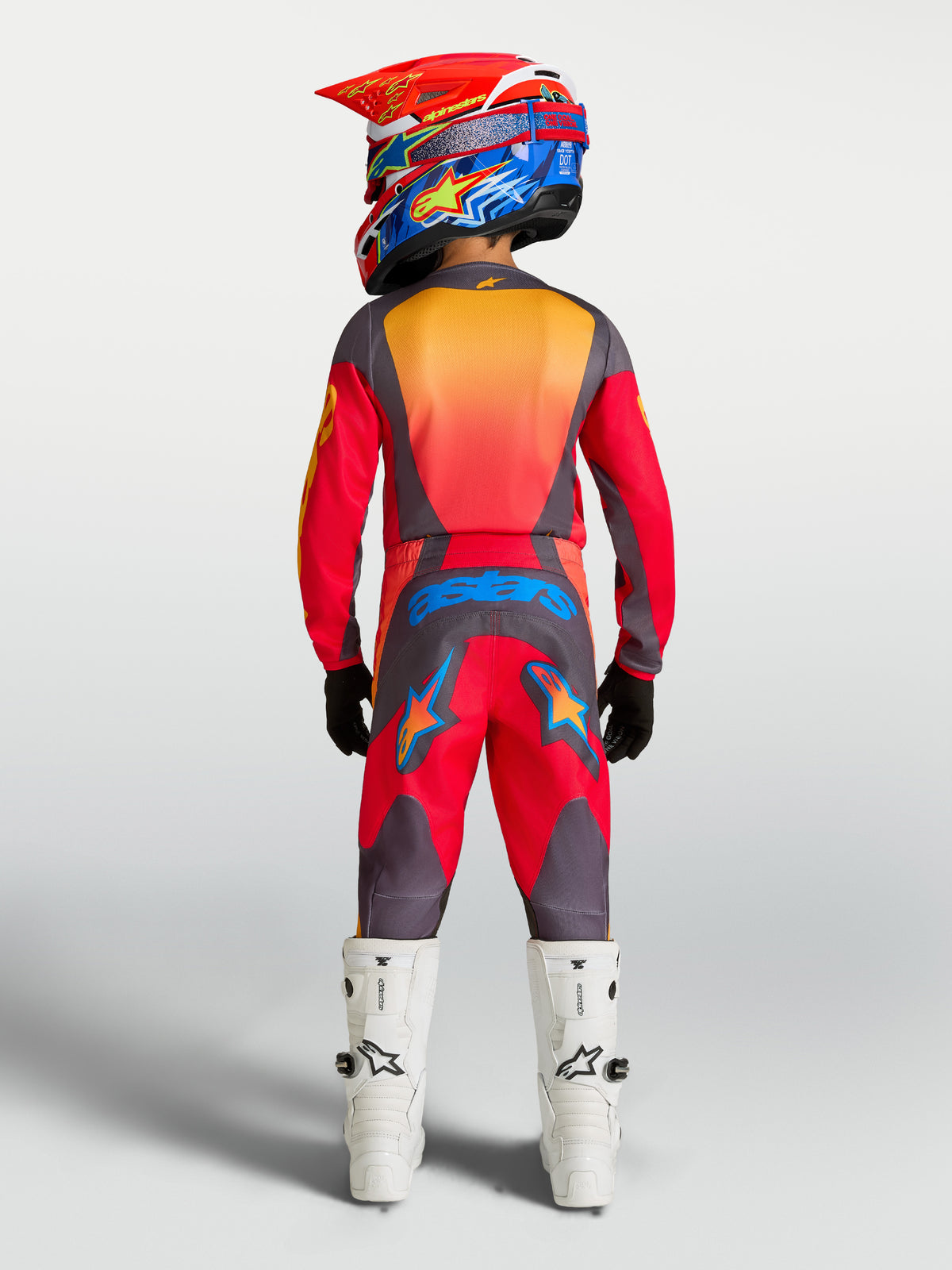 Alpinestars Youth Fluid Hunt 2027, conjunto de motocross juvenil, rojo y gris, vista trasera con botas blancas