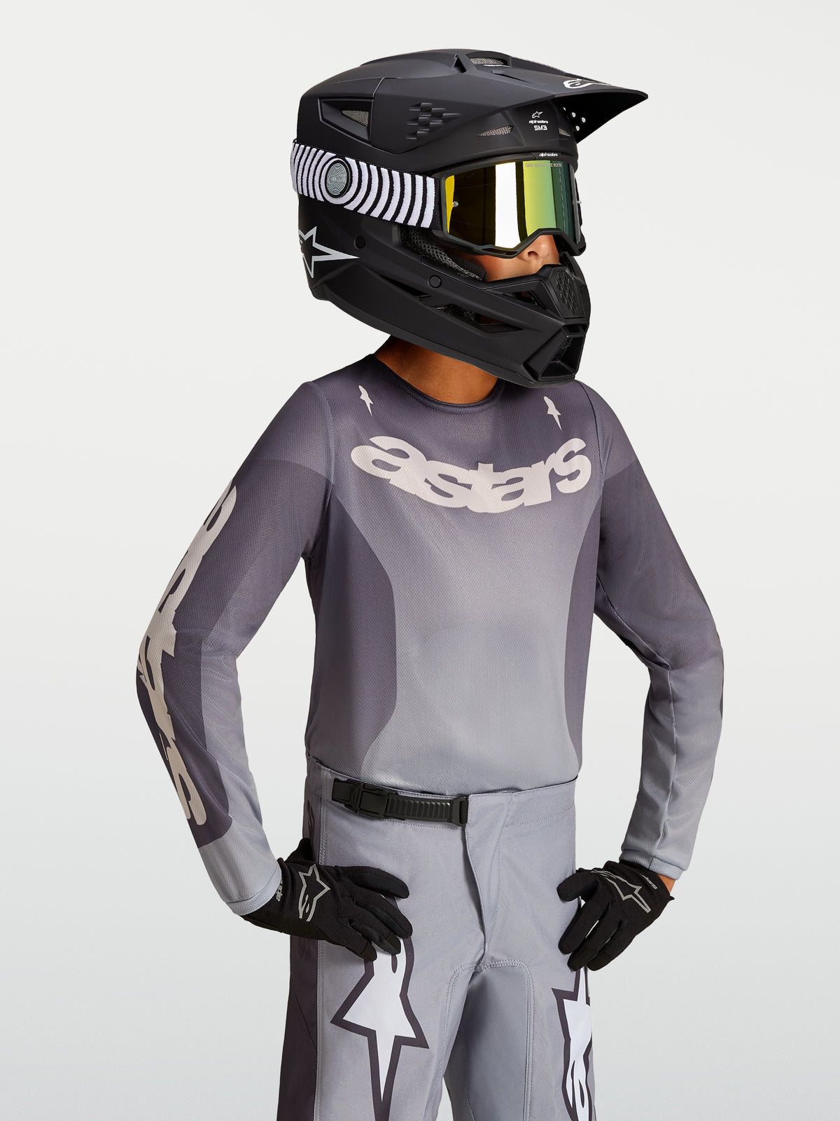 Alpinestars Jersey Fluid Amber Juvenil 2027, jersey de motocross, arena y gris, modelo con casco negro