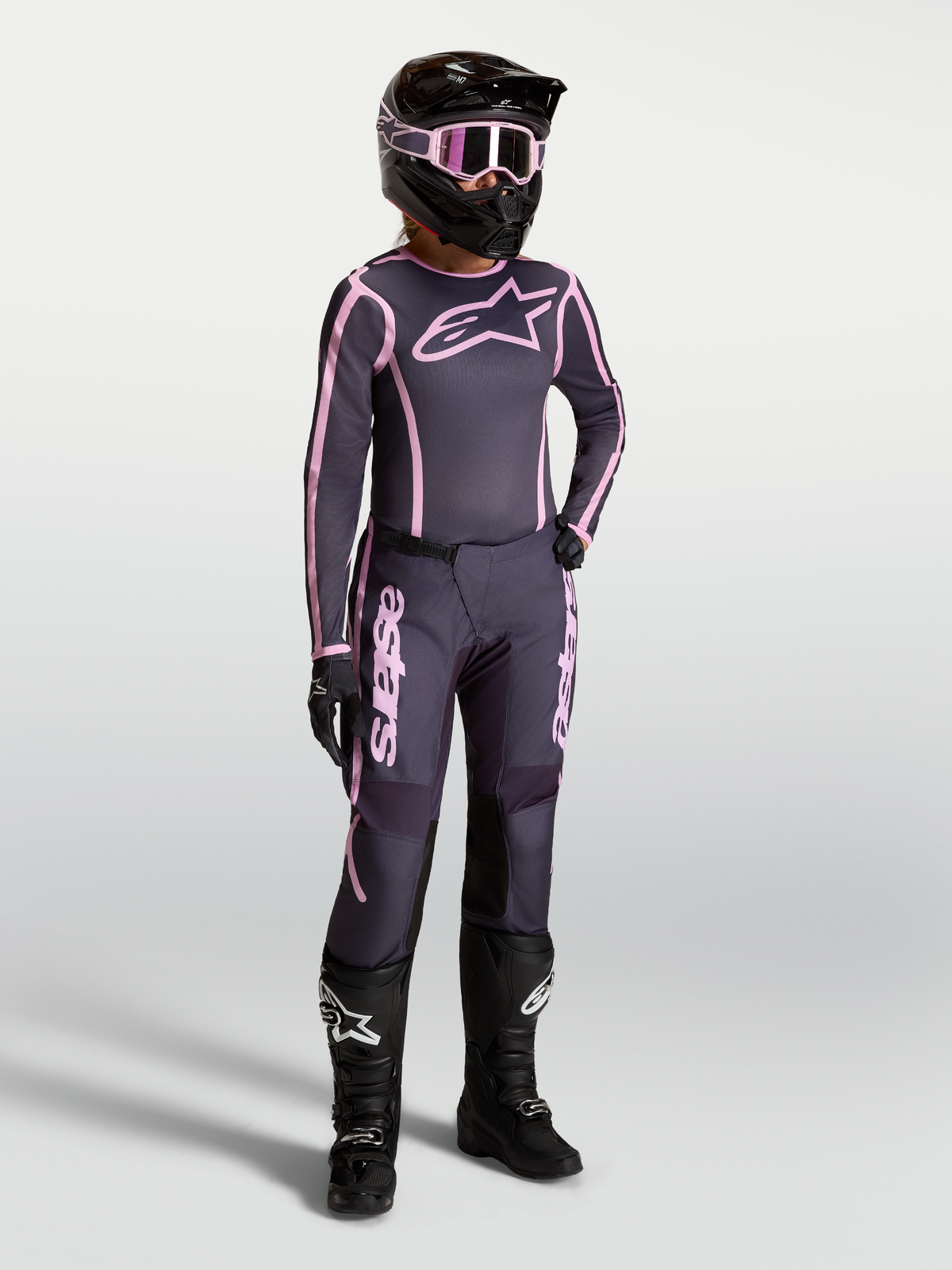 Alpinestars Stella Fluid Apex V2, jersey y conjunto de motocross para mujer, gris y rosa con botas de carreras negras.