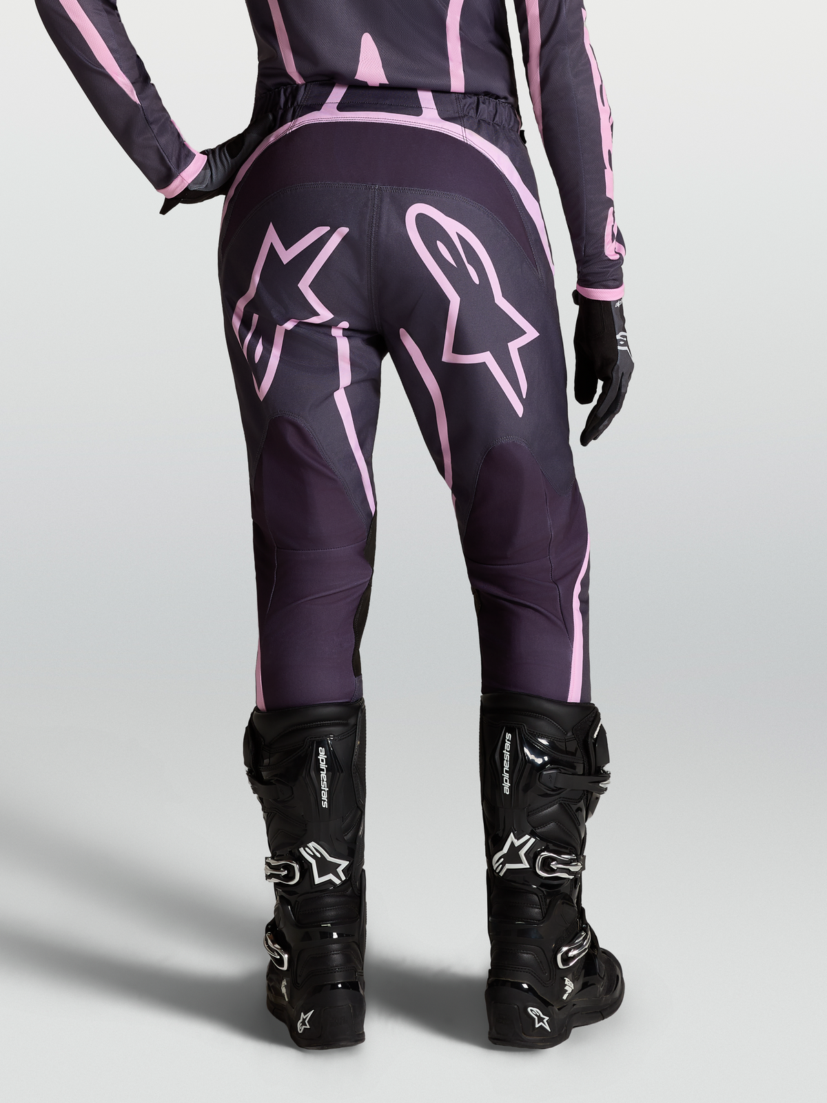 Alpinestars Stella Fluid Apex V2 Pants, Women's Motocross Pants in Graystone and Pink with Star graphics and black boots.