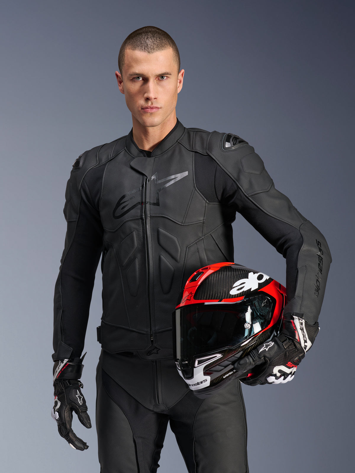 Alpinestars Dusk, chaqueta de moto para carreras, hombre, negra, cuero, protección Nucleon PLASMA y modelo con casco rojo