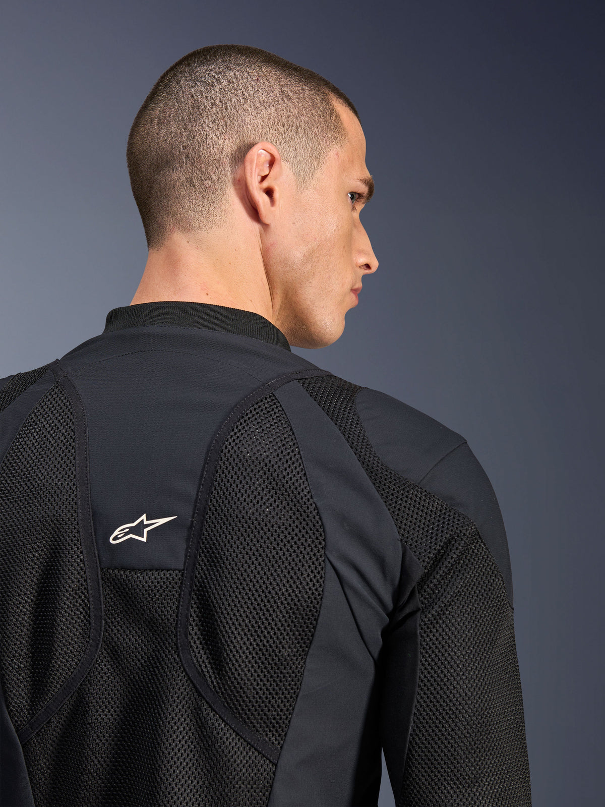 Chaqueta Alpinestars Troop-Air Pro, negra, vista de primer plano de la espalda con paneles de malla técnica transpirable y logotipo de estrella blanca, chaqueta de aire blindada premium para conducción de motocicletas