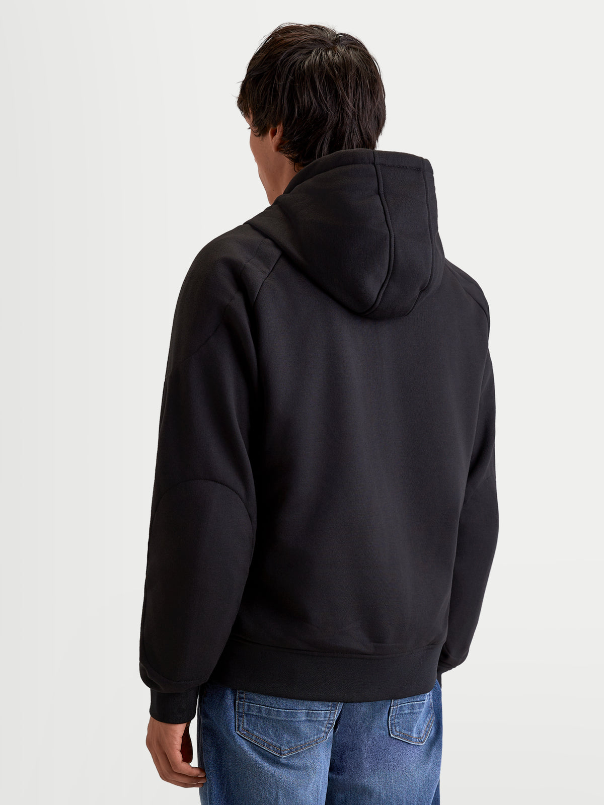 Alpinestars Chaqueta Con Capucha Ageless, sudadera de moto urbana para hombre en color negro, vista trasera en un modelo que muestra la capucha fija y la construcción textil informal