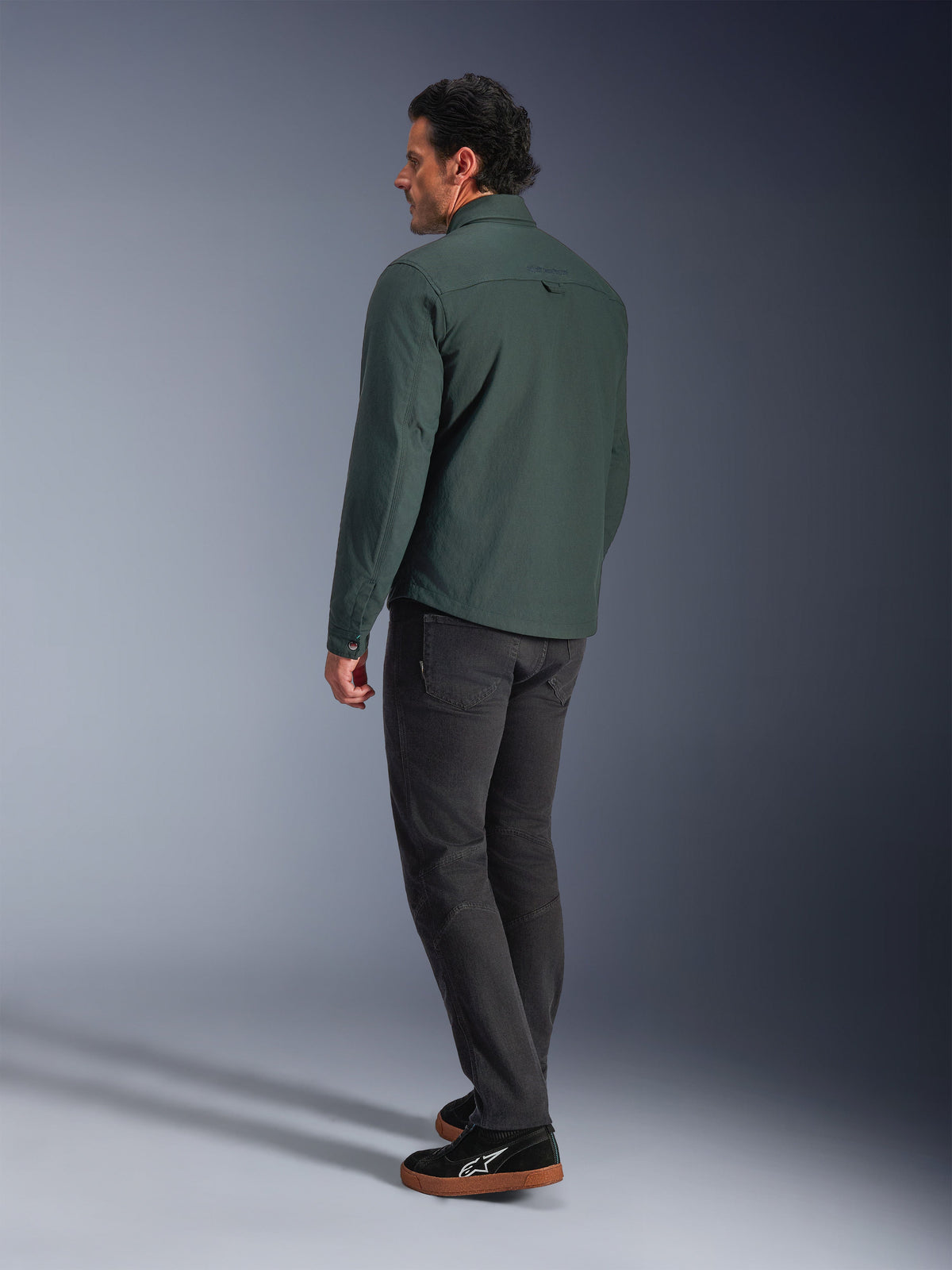 Alpinestars Bryon Water Resistant Overshirt, Dark Emerald green, back view of an urban motorcycle jacket, worn with dark trousers and black sneakers, showcasing a modern workwear-inspired design.