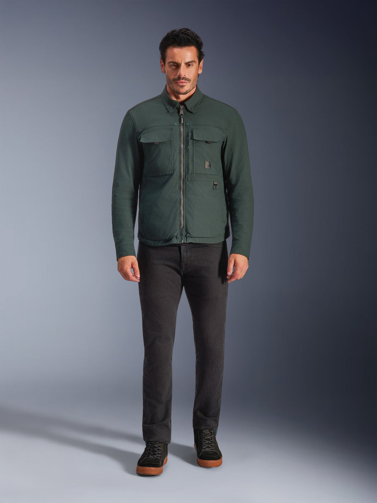 Alpinestars Bryon WR Overshirt, Water-Resistant Motorcycle Jacket, Dark Emerald, worn with black pants and black boots, featuring waxed canvas construction, chest cargo pockets, and a modern urban design.