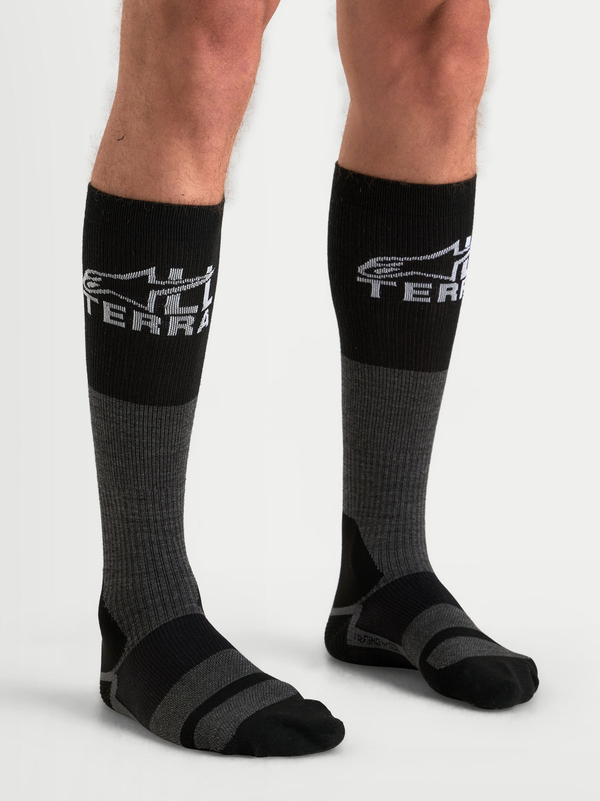 Alpinestars AT-8 Merino Calcetines de moto de aventura, grises y negros, con mezcla de lana merina y marca All Terra, puestos en modelo