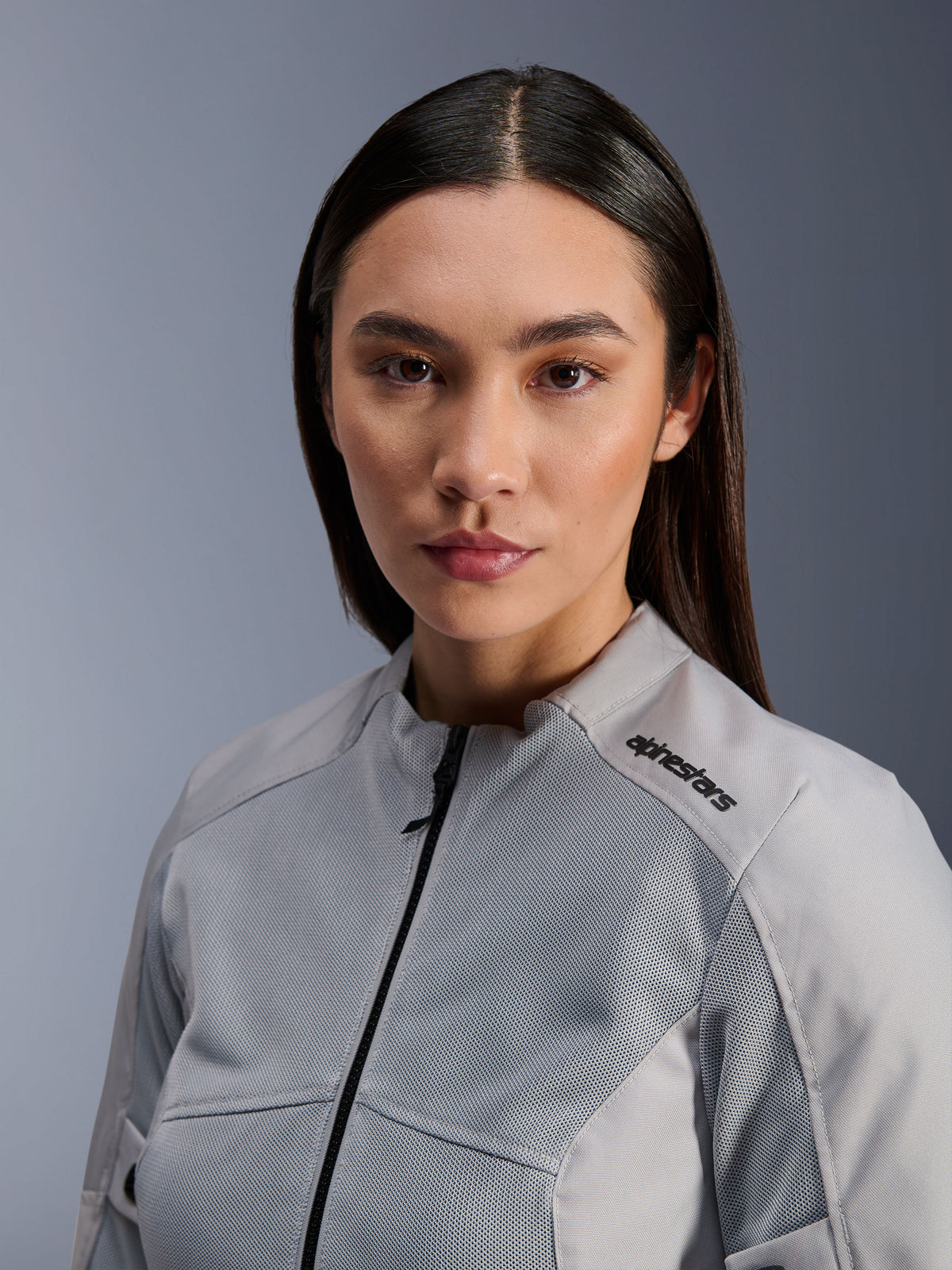 Chaqueta Alpinestars Stella C-1 Air, chaqueta de moto plateada para mujer, primer plano que muestra paneles de ventilación de malla técnica y logotipo negro en el hombro, equipamiento de conducción urbana contemporánea
