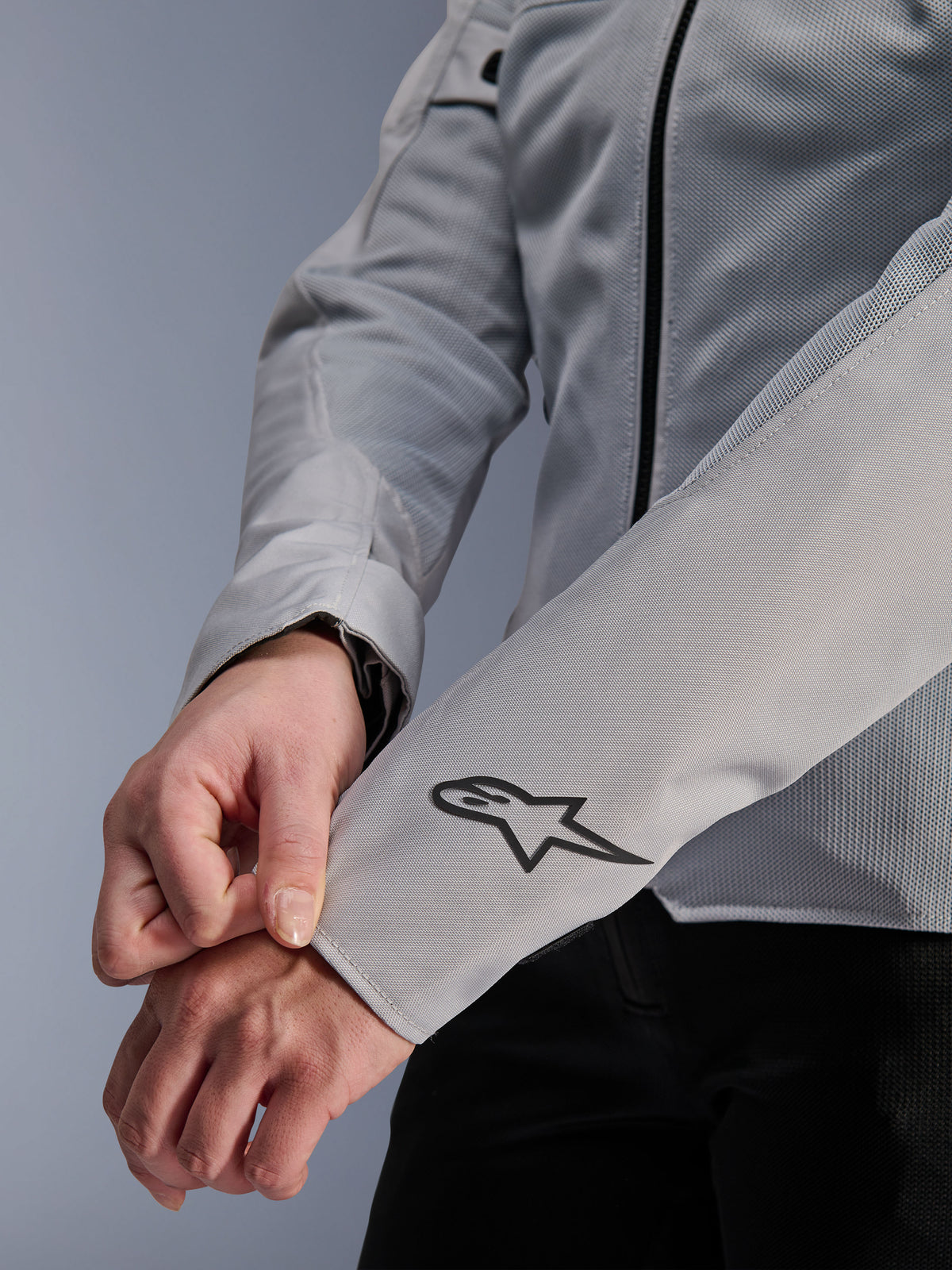 Primer plano de la chaqueta Alpinestars Stella C-1 Air en color plata, con construcción de malla técnica y un logotipo negro de Alpinestars en la manga izquierda, chaqueta de moto urbana para mujer con marca reflectante.
