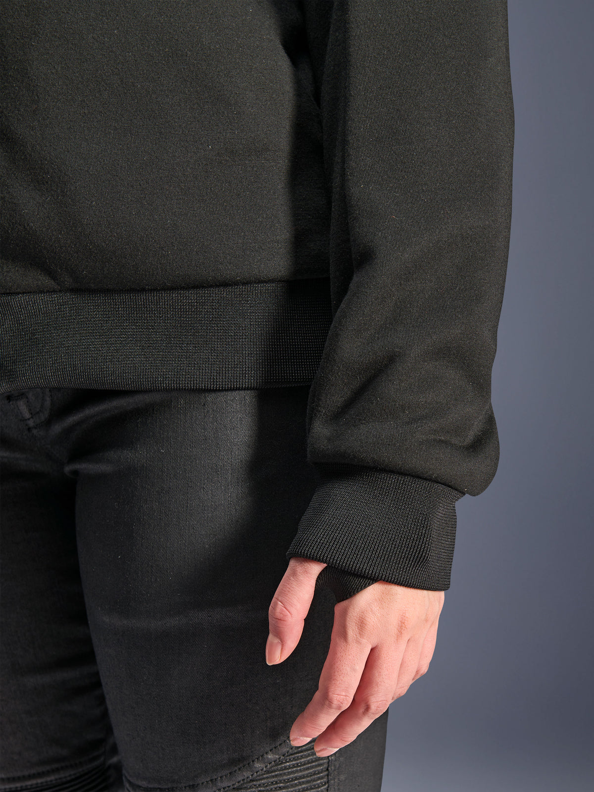Sudadera Alpinestars Stella Chrome V2 Sport, negra, primer plano del puño acanalado con orificio para el pulgar y dobladillo de la cintura acanalado, material de forro polar técnico para conducción urbana en moto
