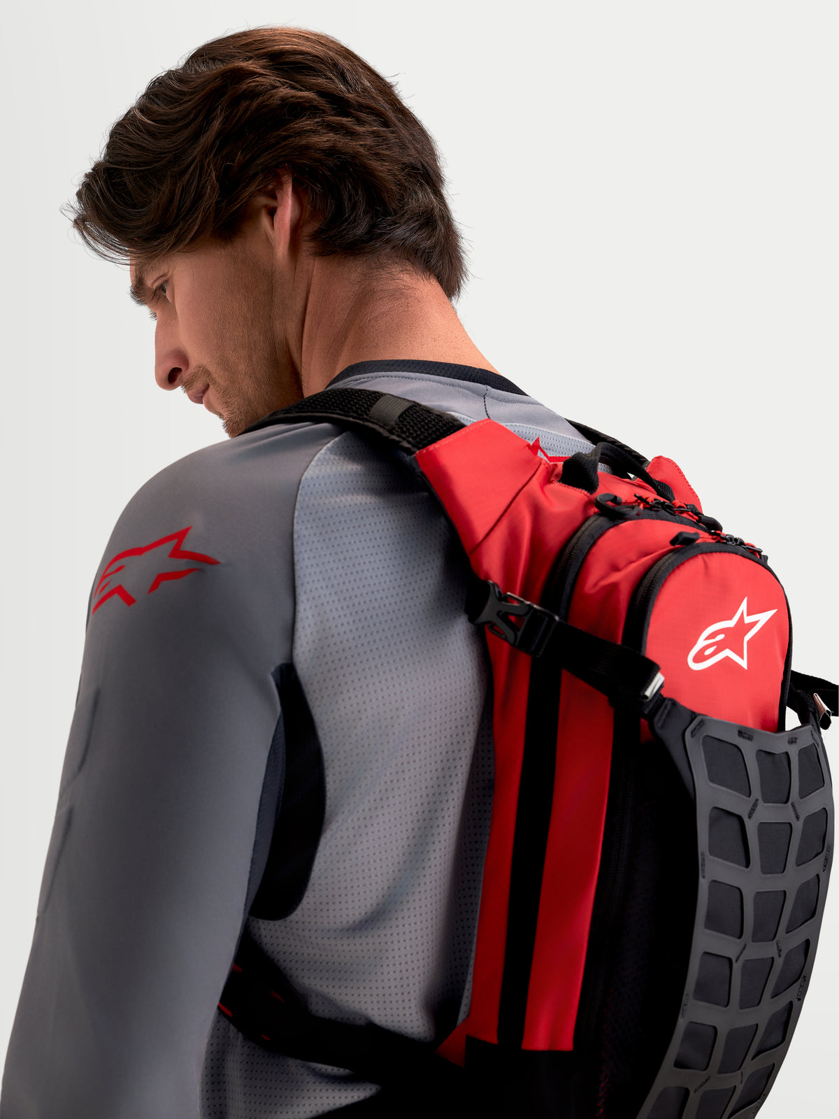Alpinestars Mochila AT-9, mochila de motocross, roja y negra, con correas acolchadas para los hombros, vista en modelo masculino