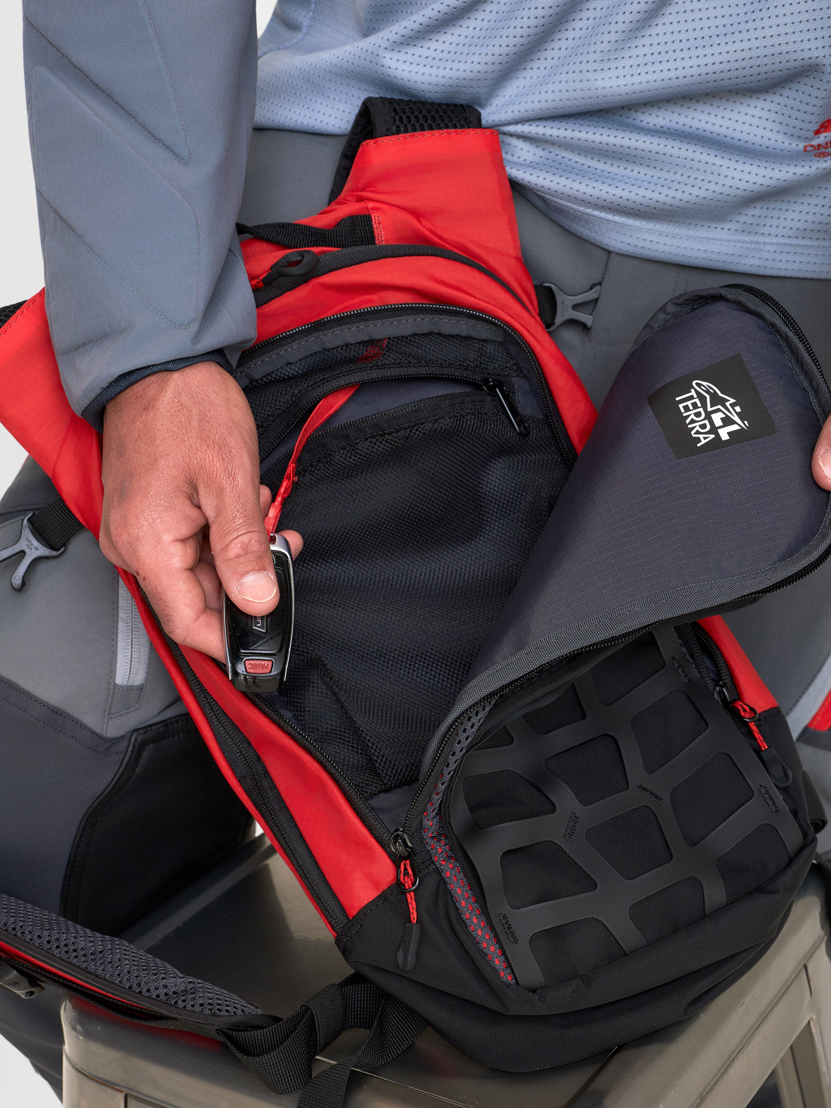Alpinestars Mochila AT-9, mochila de motocross, roja y negra, vista en primer plano con compartimentos de almacenamiento organizados y cierre de cremallera en modelo