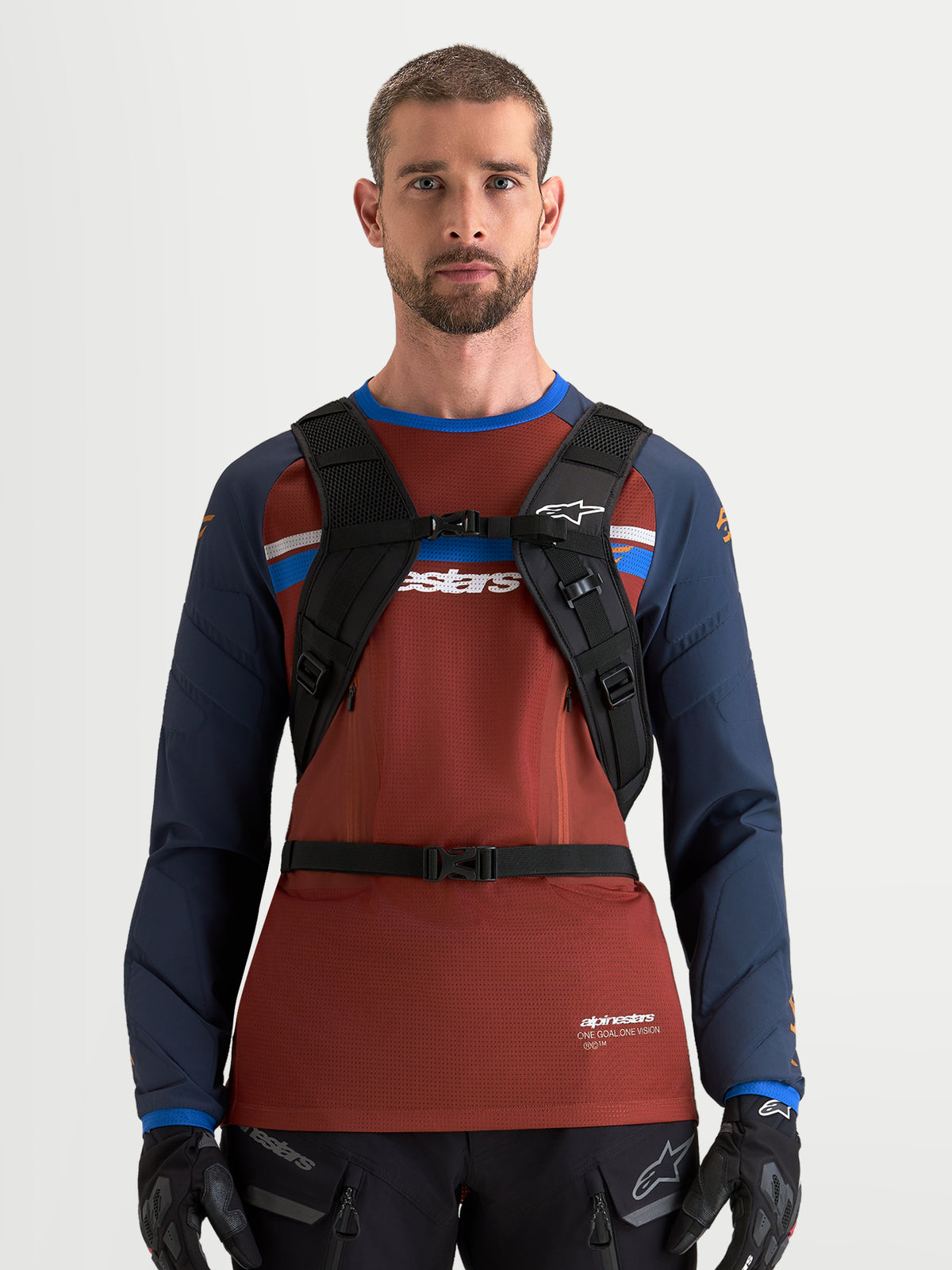 Alpinestars Mochila AT-9, mochila de motocross para hombre, negra y gris oscuro, con arnés de hombro acolchado y sistema de hebilla en el pecho, vista frontal en modelo