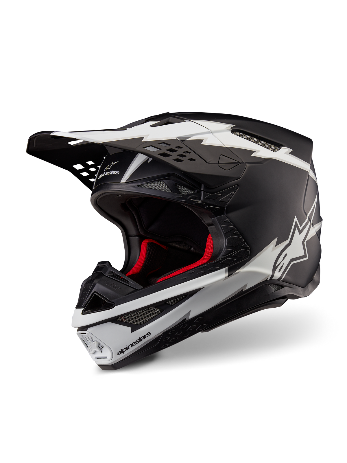 Casco Alpinestars Supertech M10 Ampress, casco de motocross, negro y blanco mate, con llamativos gráficos blancos estilo rayo y logotipos de estrella, forro interior rojo, calota de carbono multicompuesta con un perfil aerodinámico estilizado