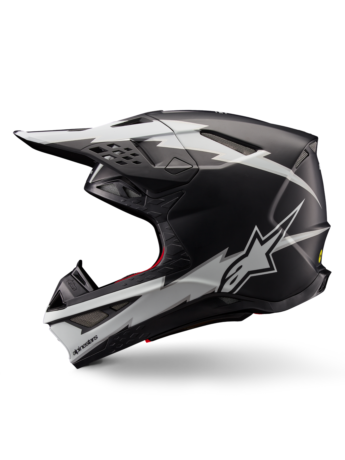 Casco Alpinestars Supertech M10 Ampress, casco de motocross, negro mate y blanco, vista de perfil con llamativos gráficos blancos estilo rayo, carcasa aerodinámica con puertos de ventilación visibles y visera, protección avanzada para todoterreno