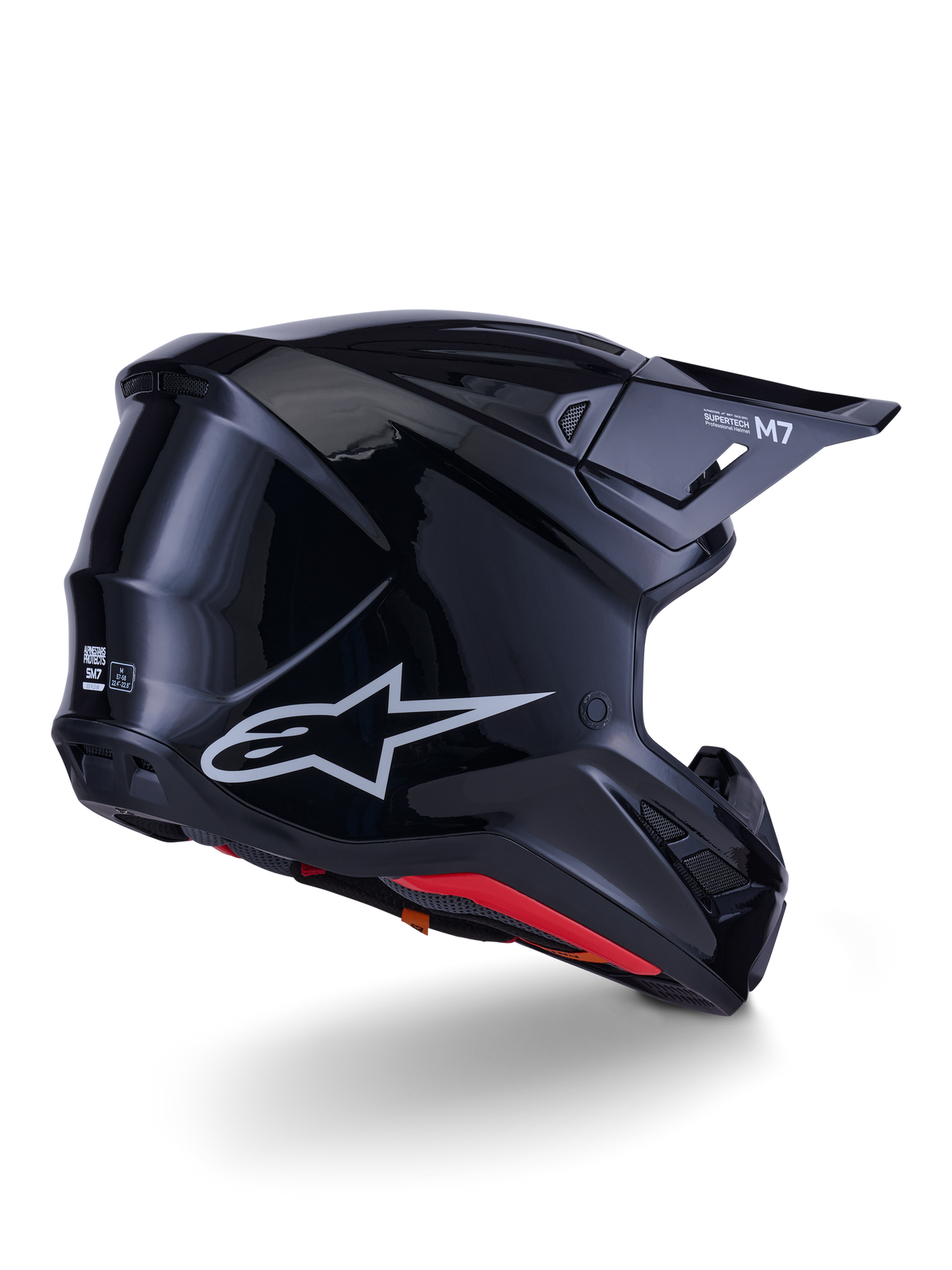 Casco Alpinestars S-M7 Solid, casco de motocross, negro brillante, con una carcasa aerodinámica estilizada, logotipo Astars plateado, forro interior rojo y puertos de ventilación integrados, diseñado para protección en carreras off-road