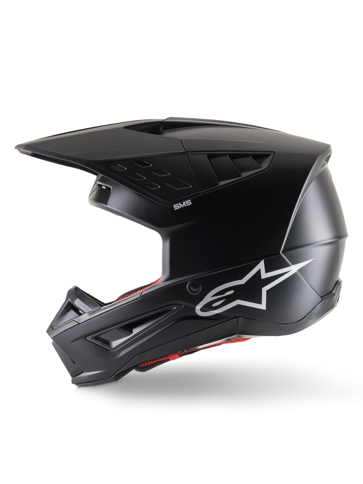 Casco Alpinestars S-M5 Solid ECE 22.06, casco de motocross, negro mate, vista de perfil lateral con un elegante acabado mate, logotipo blanco de Alpinestars en el lateral, acolchado interior rojo y carcasa aerodinámica con puertos de ventilación integrados