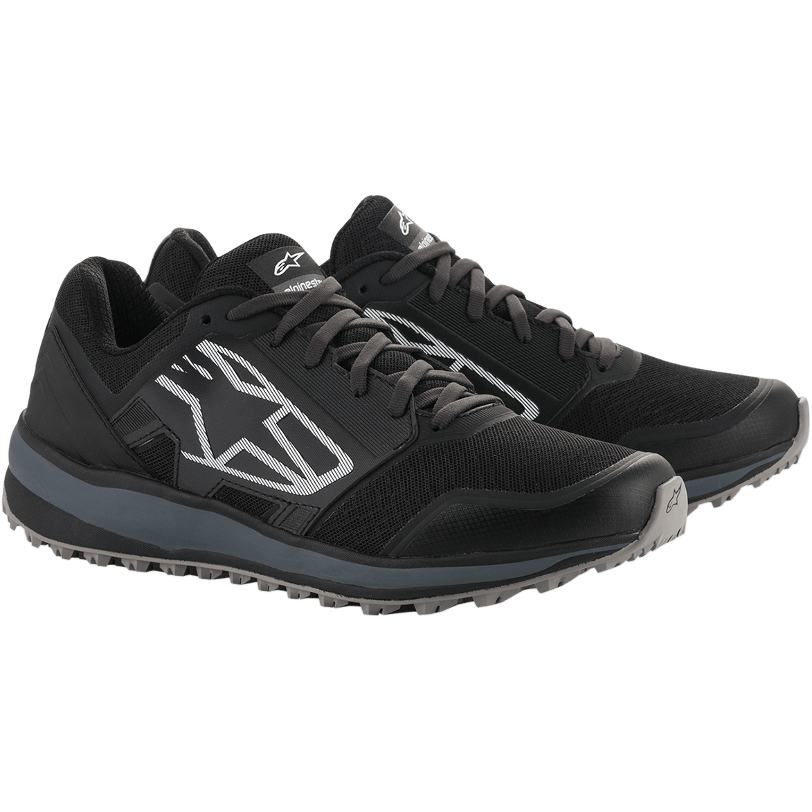 Alpinestars Meta Trail Shoes, zapatillas de running de alto rendimiento, negro y gris oscuro, gran logotipo Astars blanco con rayas en el lateral, diseño con cordones y suela gris robusta, diseñadas para brindar comodidad durante todo el día en el paddock
