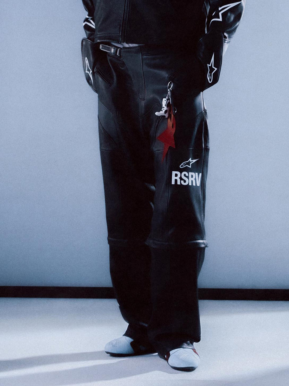 Alpinestars RSRV Neo Bat, pantalones de cuero para hombre, negros, con logo RSRV blanco, llavero en forma de estrella roja, diseño premium de cuero, estilo urbano contemporáneo