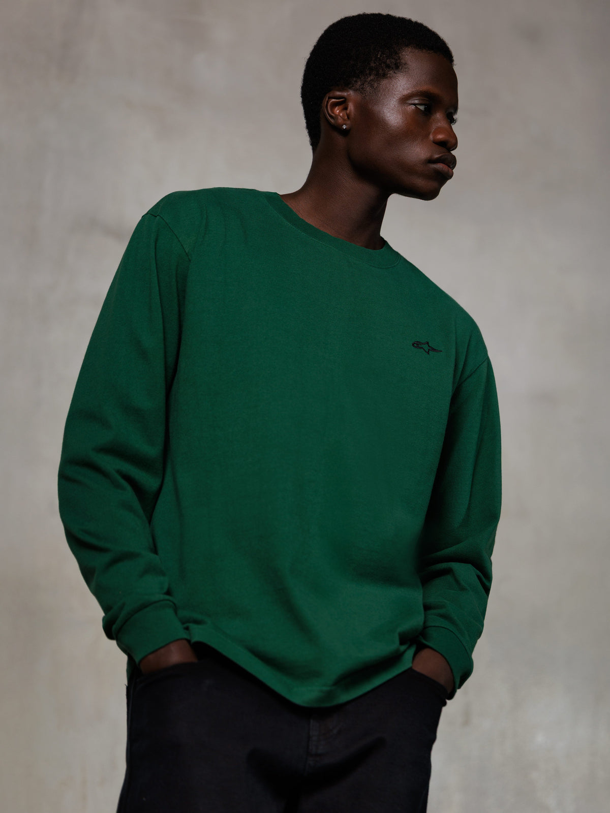 Alpinestars Essentials Ageless LS Tee, camiseta de manga larga, verde pino, pequeño logo negro en el pecho, cuello redondo, ajuste relajado, algodón orgánico premium para un estilo urbano informal
