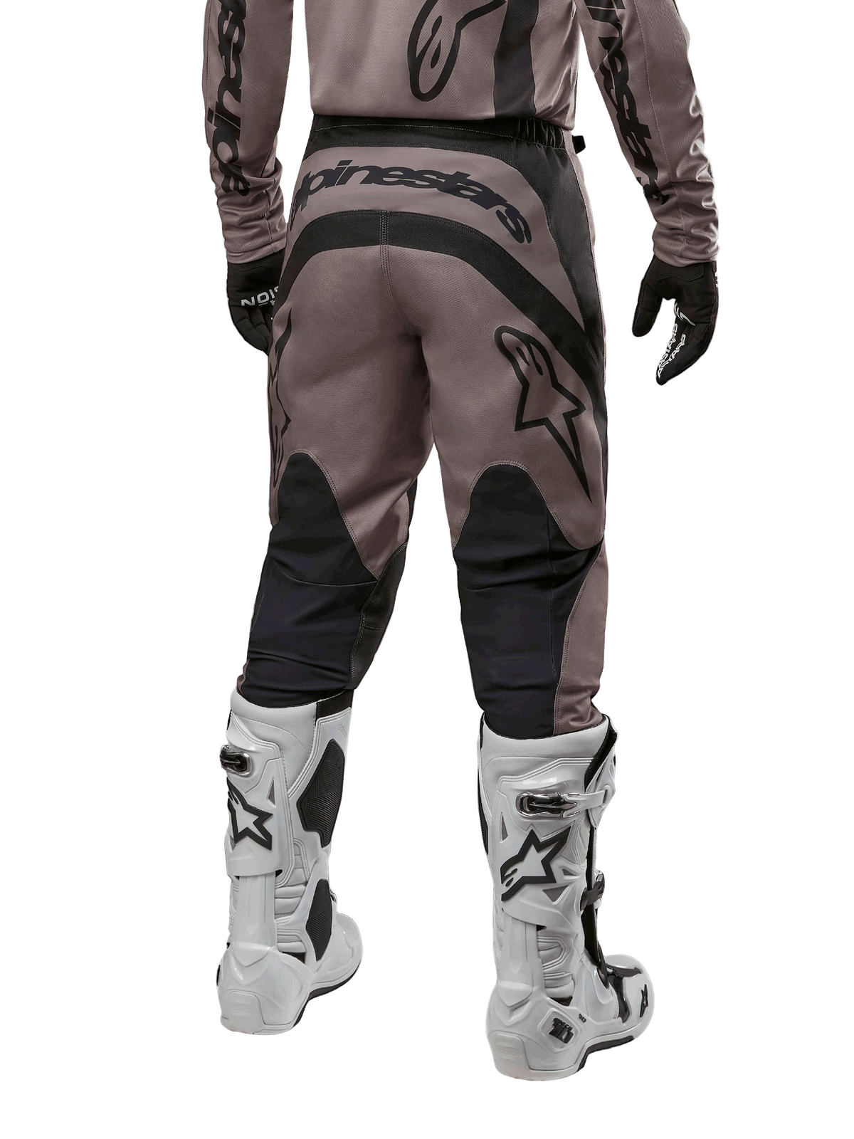 Pantalones Alpinestars Fluid Lurv 2024, pantalones de motocross, Mud Black, vista trasera con gran logotipo negro de Alpinestars en el asiento y paneles negros en las pantorrillas, combinados con botas de motocross blancas y negras y jersey a juego