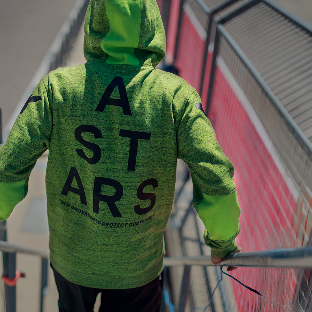 Sudadera con capucha Alpinestars Perpetuate, vista trasera, forro polar jaspeado en verde lima, gran gráfico con el texto ASTARS en negro en la espalda, prenda deportiva casual con bloques de tela y capucha con cordón