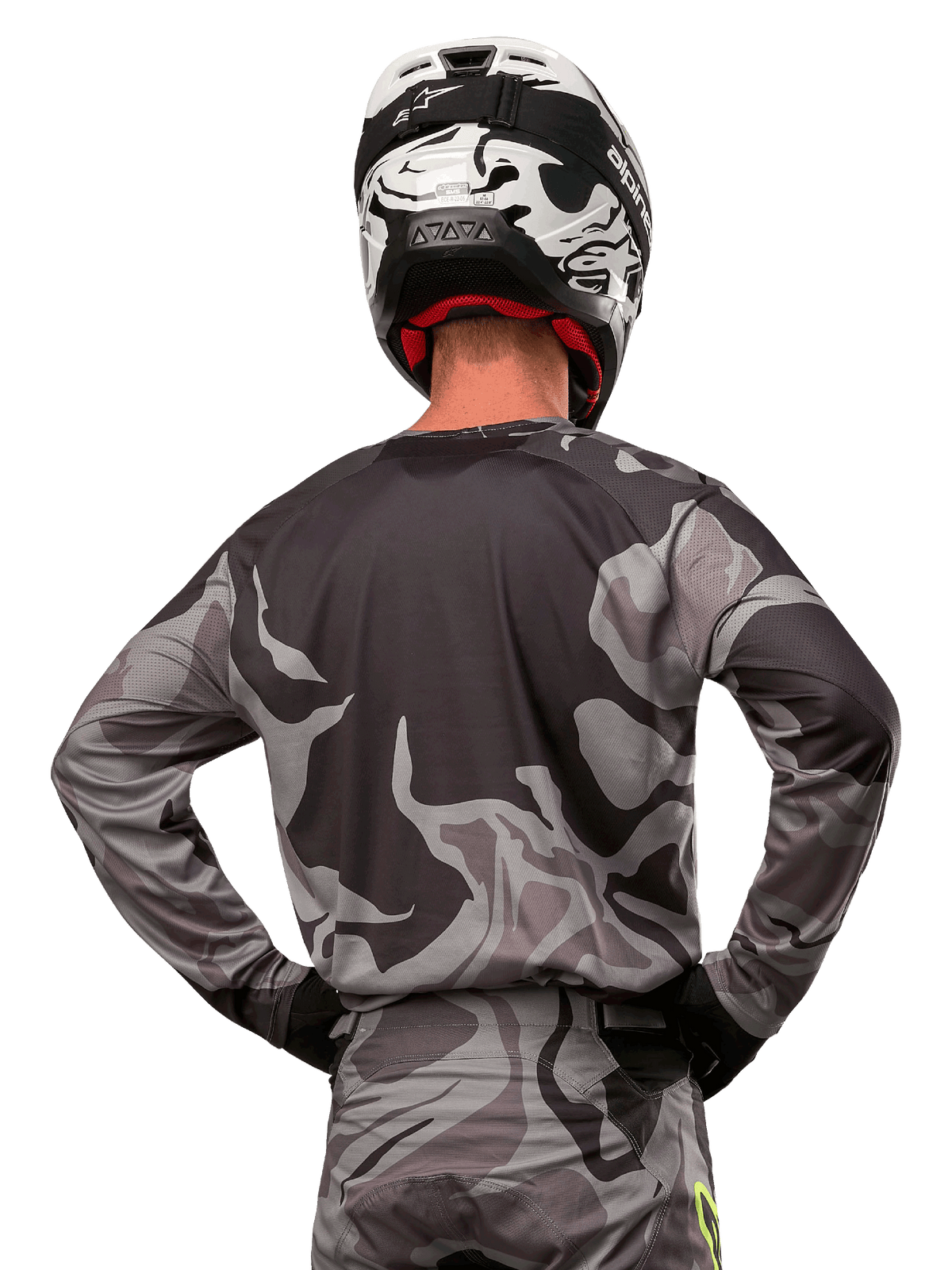 Alpinestars 2024 Racer Tactical Jersey, jersey de motocross, Cast Gray Camo Magnet, vista posterior que muestra el patrón de camuflaje gris y negro, usado con pantalones a juego y un casco blanco y negro, equipamiento profesional de carreras todoterreno
