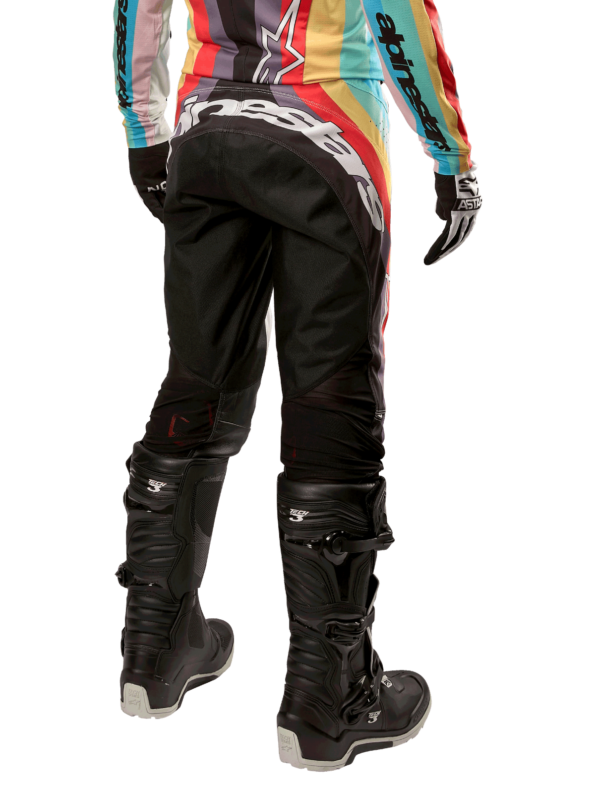 Alpinestars Stella Techstar Pants 2024 para mujer, pantalones de motocross, negro multicolor, vista trasera con marca blanca destacada en el asiento, combinados con botas Tech 3 negras y un jersey multicolor a juego, equipamiento profesional de carreras todoterreno