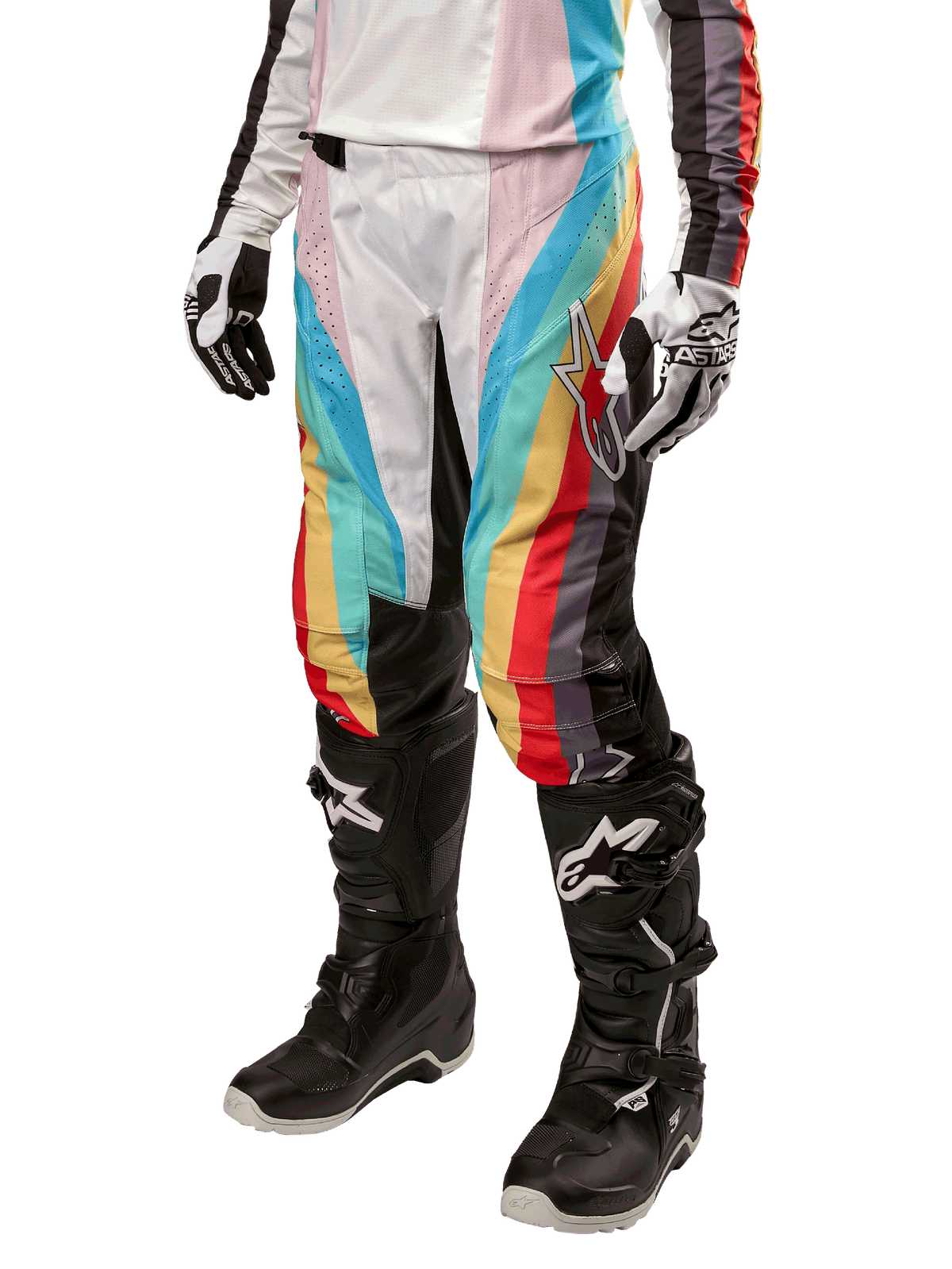 Alpinestars Stella Techstar 2024, pantalones de motocross para mujer, negro multicolor con franjas diagonales rojas, amarillas y azules, combinados con botas de montar negras y guantes blancos, con paneles protectores negros en las rodillas y marca llamativa para carreras fuera de pista
