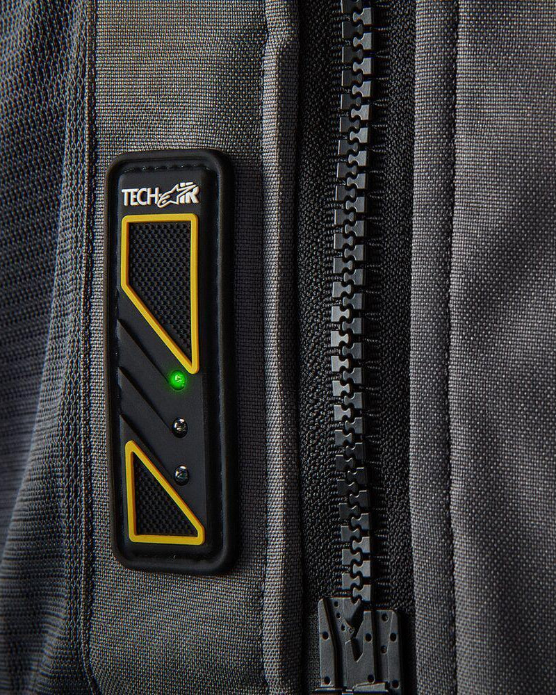Tech-Air 5 LED status panel on a dark gray textile vest, featuring a glowing green light and large black zipper.