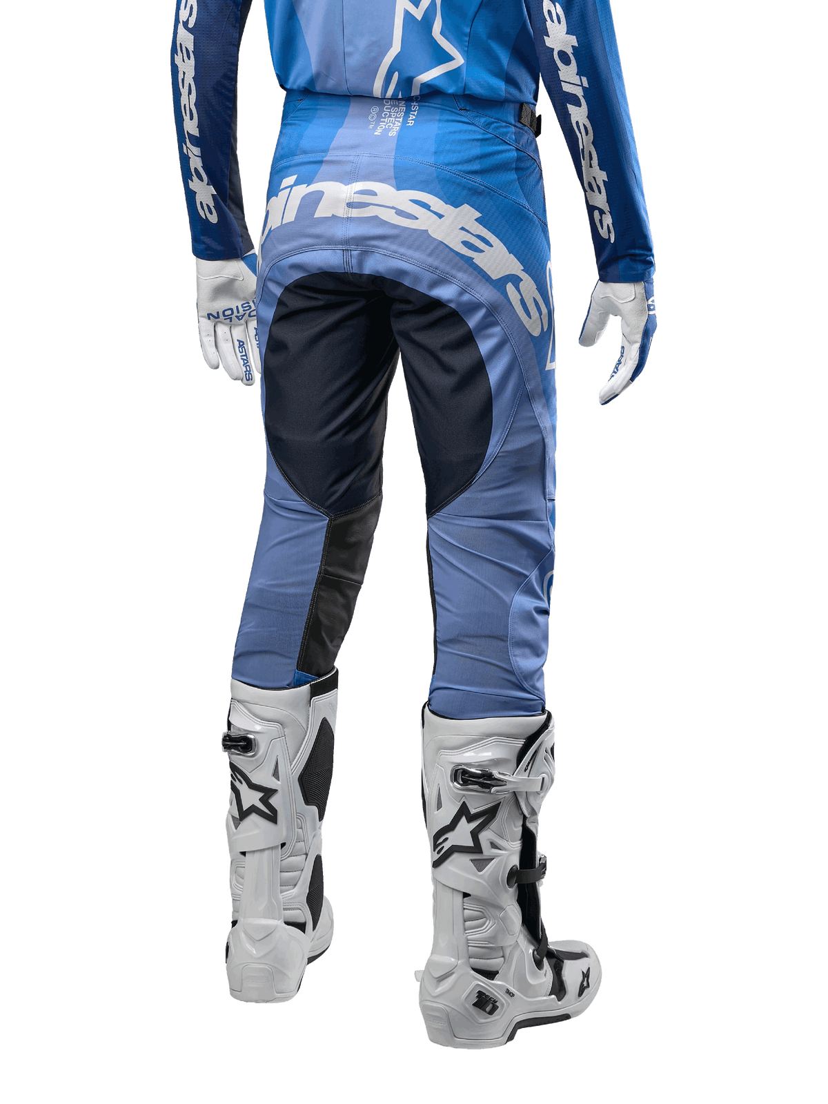 Alpinestars Techstar Pneuma Pants 2024, pantalones de motocross, azul marino y azul claro, vista trasera con logotipo blanco llamativo en el asiento y paneles negros reforzados, combinados con botas de motocross Tech 10 blancas.