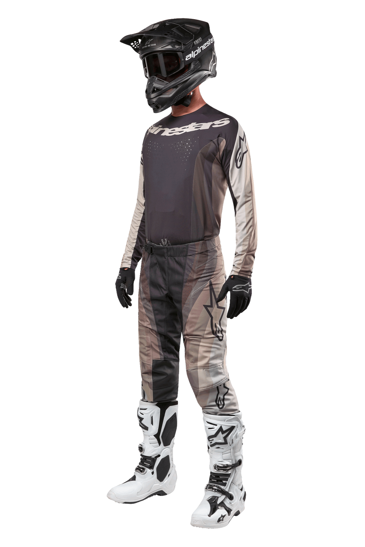 Pantalones Alpinestars Techstar Pneuma 2024, pantalones de motocross, color Dark Sand Iron Dust Gray, usados como parte de un conjunto completo de equipamiento con jersey a juego, casco negro, guantes negros y botas blancas, con patrones de camuflaje desértico en tonos similares y logotipos destacados