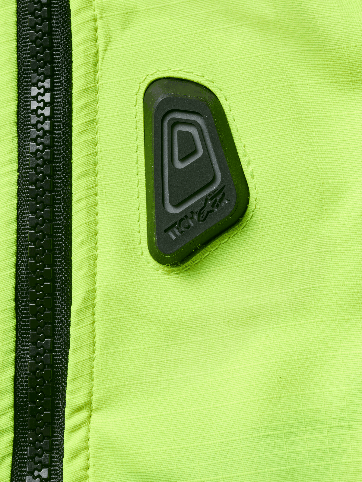 Alpinestars Tech-Air® 3 V2 System, chaleco airbag para motocicleta, primer plano de tejido resistente al agua en amarillo flúor con cremallera negra, con parche de goma negro del logo Tech-Air, equipamiento de seguridad de alta visibilidad