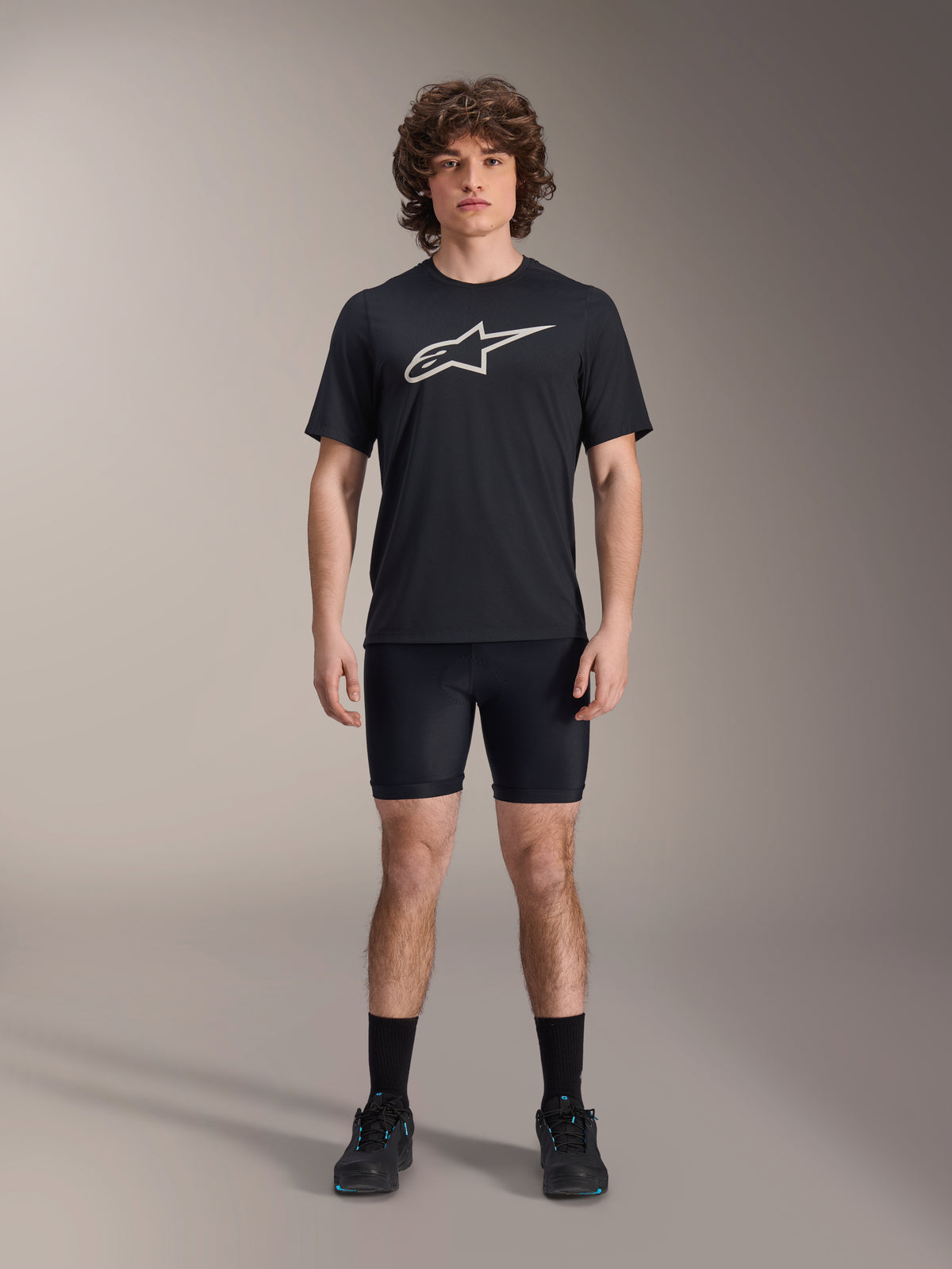 Shorts A-Dura Liner de Alpinestars, shorts interiores de ciclismo negros, vestidos por un modelo con una camiseta negra con el logo de Alpinestars y zapatillas de ciclismo negras, diseño ajustado para rendimiento en MTB y comodidad en el sillín.