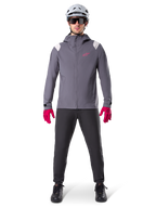 Alpinestars A-Dura Rain Jacket, chaqueta de ciclismo de montaña, gris titanio oscuro con logotipo rosa, combinada con casco de MTB gris y guantes rosa intenso, diseño de membrana protectora de 2,5 capas para ciclismo en climas húmedos