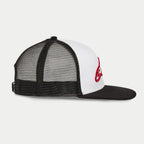 Gorra Alpinestars Corp Trucker, blanco y negro, perfil lateral que muestra el panel frontal blanco con logotipo rojo bordado en 3D, visera plana negra y parte trasera de malla, estilo casual motorsport streetwear