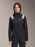 Alpinestars Stella A-Dura Rain Jacket, chaqueta impermeable de ciclismo para mujer, negra con paneles gris claro en los hombros, chaqueta técnica con capucha y logo blanco en el pecho, puños ajustables con velcro, equipamiento profesional para MTB y conducción en climas húmedos